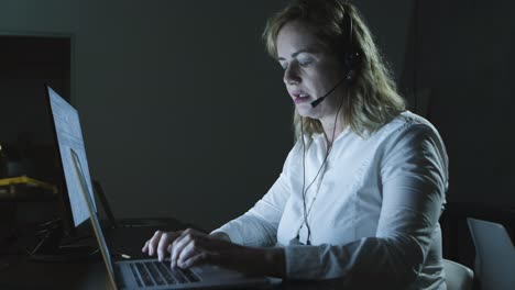 Focused-woman-in-headset-using-laptop